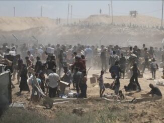Crowd gathering in a dusty open area.