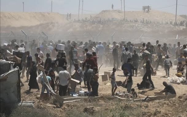 Crowd gathering in a dusty open area.