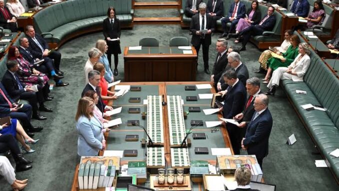 Politicians standing in a parliamentary chamber session. Politicians standing in a parliamentary chamber session.