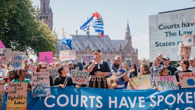 Protesters with signs at climate justice rally. Protesters with signs at climate justice rally.