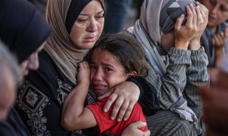 Woman comforting crying child, others in distress.