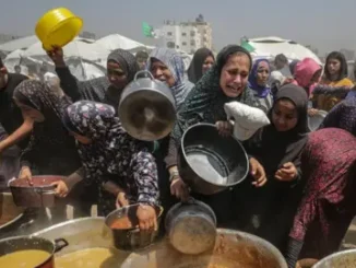 People gathering for food distribution in camp.