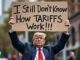 Man holding sign about tariffs confusion.