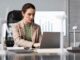 Woman working on laptop in office.