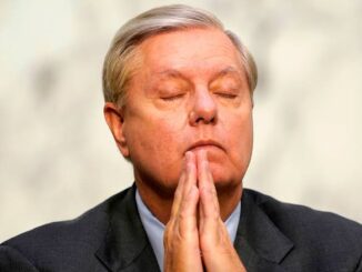 Man with closed eyes and clasped hands.