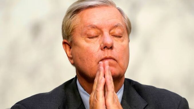 Man with closed eyes and clasped hands.