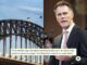 Bridge, man speaking, and text overlay.
