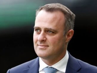 Man in suit with neutral expression.