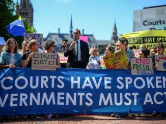 Climate protest with banners and diverse crowd.