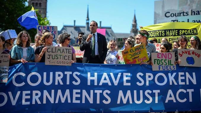Climate protest with banners and diverse crowd.