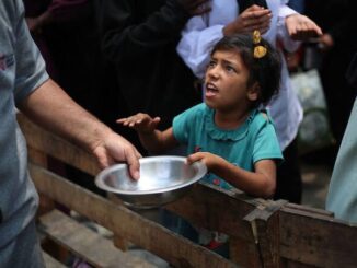 Child receiving food from an adult.