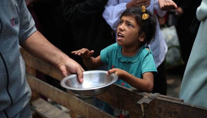 Child receiving food from an adult.