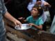 Child receiving food from an adult.