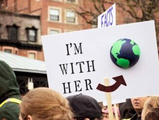 Protest sign with "I'm with her" message.