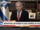Man speaking in TV interview with news banner.