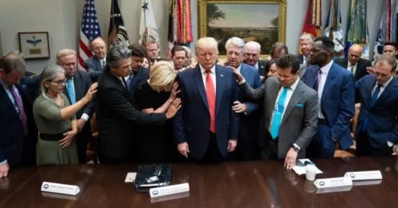 Group gathered around a central figure, praying. Group gathered around a central figure, praying.