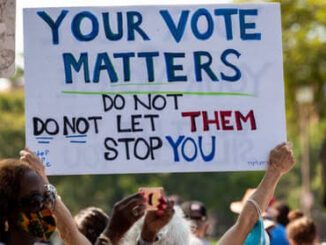 Protest sign: "Your vote matters" message.