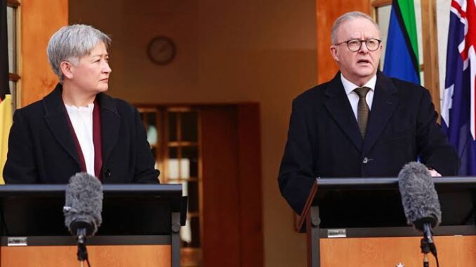 Two speakers at podiums with microphones and flag Two speakers at podiums with microphones and flag