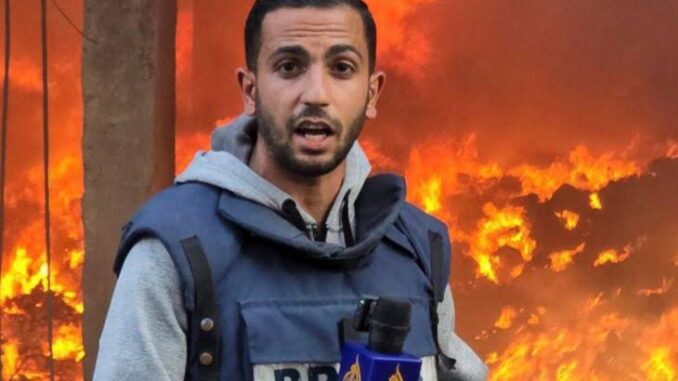 Reporter in front of large, raging fire. Reporter in front of large, raging fire.