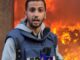 Reporter in front of large, raging fire.