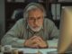 Man focused on computer screen at desk.