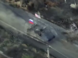 Aerial view of vehicle with flags on road.