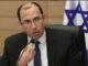 Man speaking at a meeting, Israeli flag.