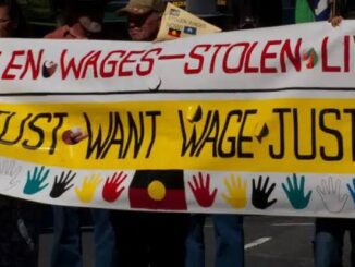 Protesters holding banners demanding wage justice.