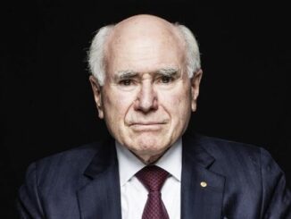 Elderly man in suit against dark background.