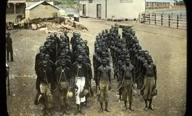 Men standing in chains outside industrial buildings. Men standing in chains outside industrial buildings.