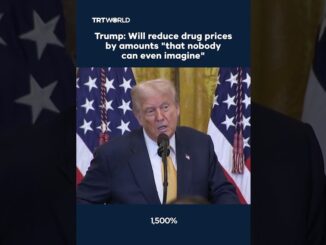Speaker at podium framed by multiple flags