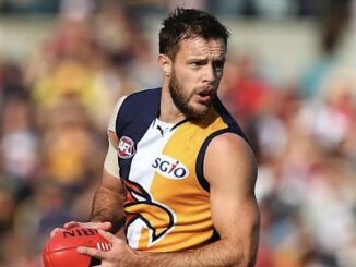 AFL player holding ball during game.