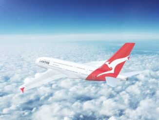 Airplane flying above clouds in clear sky.