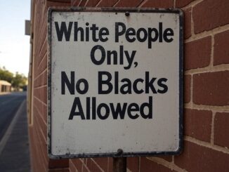 Racist sign on brick wall.