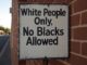Racist sign on brick wall.