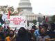 Protesters with signs in front of Capitol.
