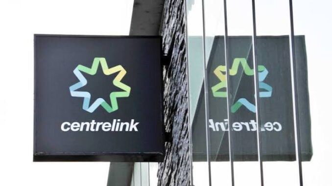 Centrelink sign with reflection on glass.
