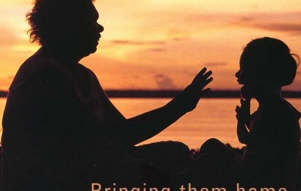 Silhouettes of adult and child at sunset.