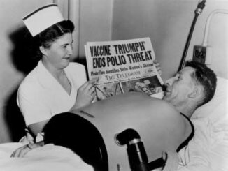 Nurse shows newspaper to patient in bed.