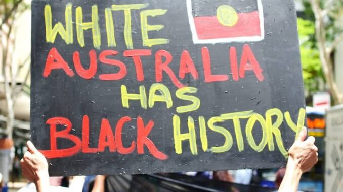 Protest sign reading "White Australia Has Black History.