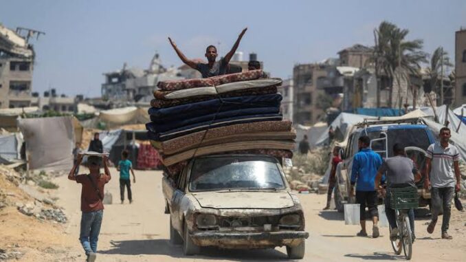 Man on car with stacked mattresses, cheering. Man on car with stacked mattresses, cheering.
