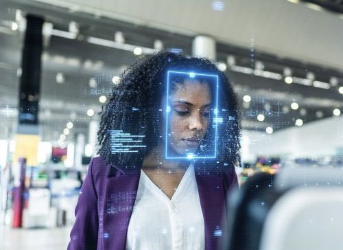 Woman interacting with facial recognition technology. Woman interacting with facial recognition technology.