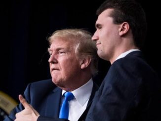 Two men in suits, one giving thumbs up.