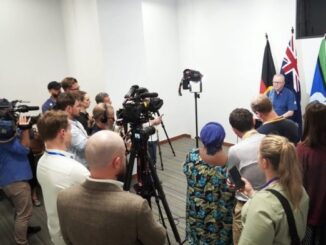 Press conference with multiple cameras and people.