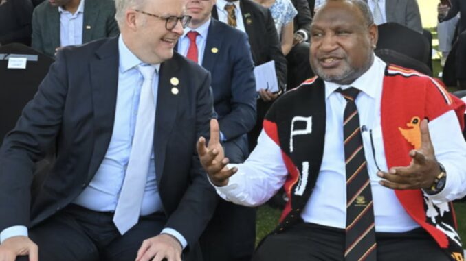 Two men seated, talking at an event. Two men seated, talking at an event.