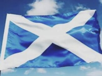Scottish flag waving against blue sky.
