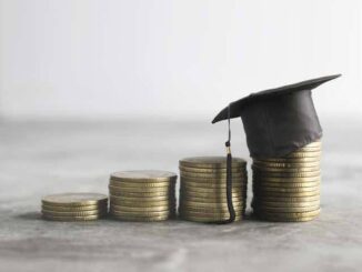 Stacks of coins with graduation cap.