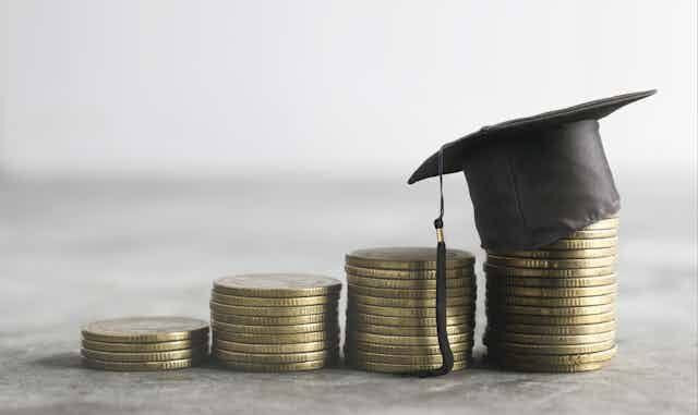 Stacks of coins with graduation cap.