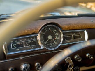 Vintage car dashboard with speedometer and gauges.
