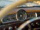Vintage car dashboard with speedometer and gauges.
